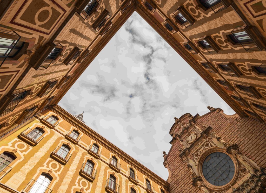 Architekturfotografie von unten: Barocker Innenhof mit verzierten Fassaden und Kirchturm – Froschperspektive zeigt ornamentale Details historischer Gebäude